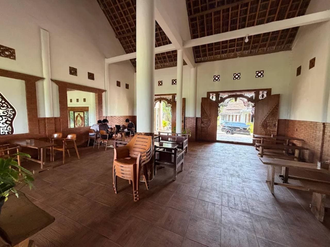 Ruang duduk Palereman dengan kursi kayu, tiang tinggi, dan atap tradisional